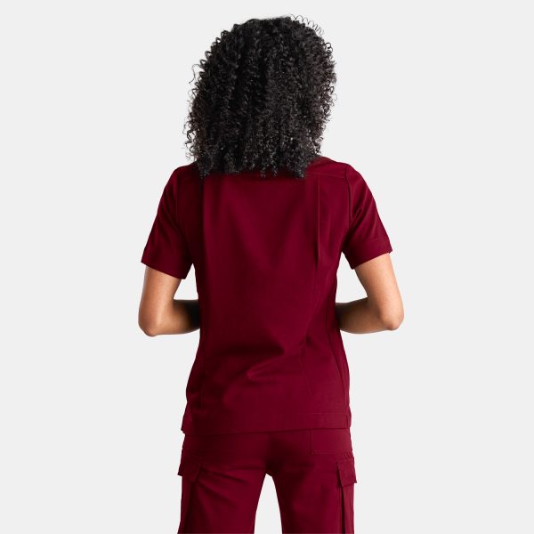 Photo Showcasing Our Modern Scrub Top on a Female Healthcare Professional Confidently Wearing Vibrant Sangria Red