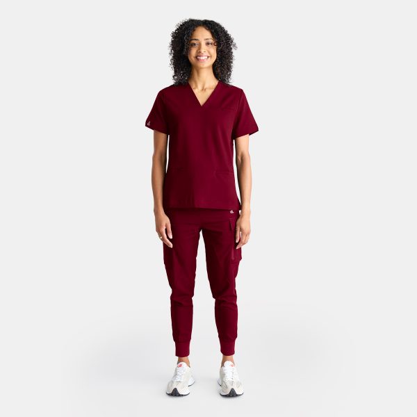 Photo Showcasing Our Cargo Pants' Pockets on a Female Healthcare Professional Confidently Wearing Vibrant Sangria Red Cargo Jogger Scrub Pant