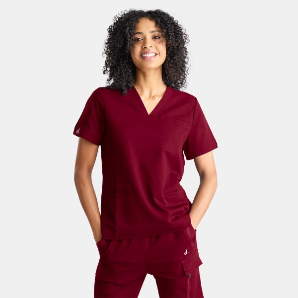 Photo Showcasing Our Modern Scrub Top on a Female Healthcare Professional Confidently Wearing Vibrant Sangria Red