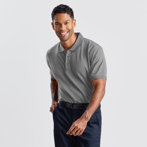 a Man in a Grey Marle Cotton Polo Shirt, with a Warm Smile, Poses with Hands on Hips, Showcasing the Shirt's Relaxed Fit and Classic Polo Collar.