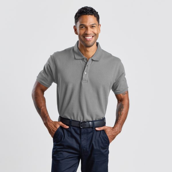 a Man Standing Confidently in a Grey Marle Cotton Polo Shirt and Navy Trousers, Radiating a Comfortable Yet Professional Look Suitable for Versatile Settings.