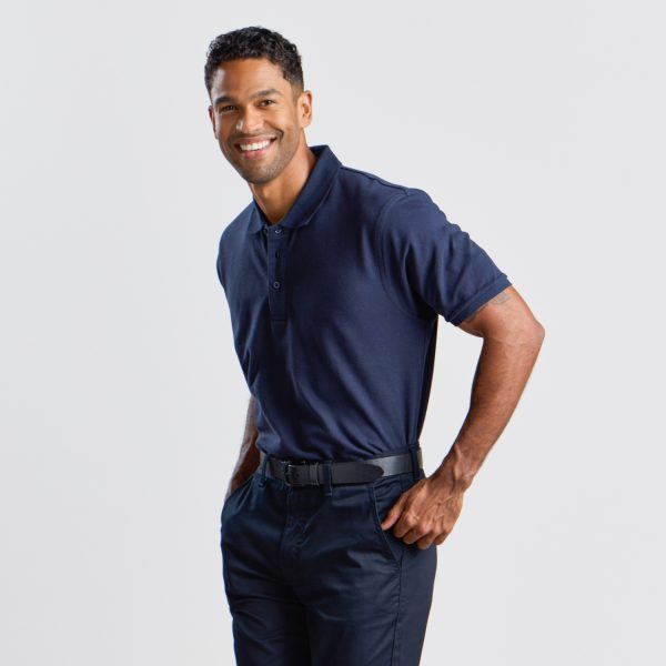 a Man Poses with His Hand on His Hip, Wearing a Navy Men's Cotton Polo, Conveying a Smart Casual Style with a Comfortable Fit Against a White Background.