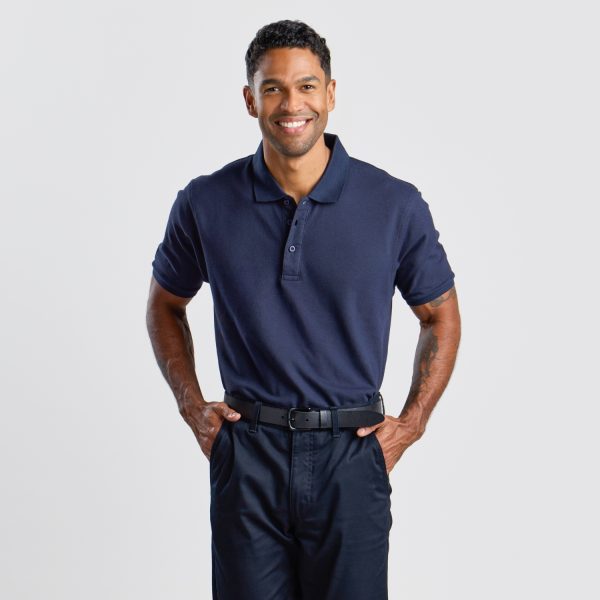 a Man with a Friendly Smile, Dressed in a Navy Men's Cotton Polo Paired with Dark Trousers, Exuding Casual Professionalism Ideal for a Range of Industries.