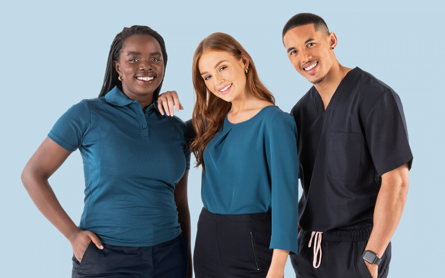 The banner for the article '3 Mistakes to Avoid When Choosing a Uniform Supplier' depicts three young, professional looking models wearing stylish, high-quality blue and navy uniforms manufactured by Designs To You. They're smiling confidently at the camera and standing in front of a a light blue background.