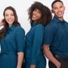 the Banner for the Article 'why Uniforms Are Great for Business' Depicts Two Female, and One Male Model Looking Happy, Confident and Smiling for the Camera in Front of a White Background. They Are Each Wearing High-quality, Professional and Sophisticated Uniforms Manufactured for Designs to You That Happen to Be the Same Shade of Deep Teal. Together, They Present a Polished and Stylish Image of Young, Business Professionals.