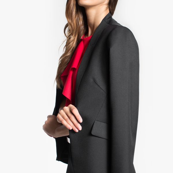 a Partial View of a Woman Wearing a Sleek Charcoal Blazer, Accented with a Vivid Red Blouse Underneath.