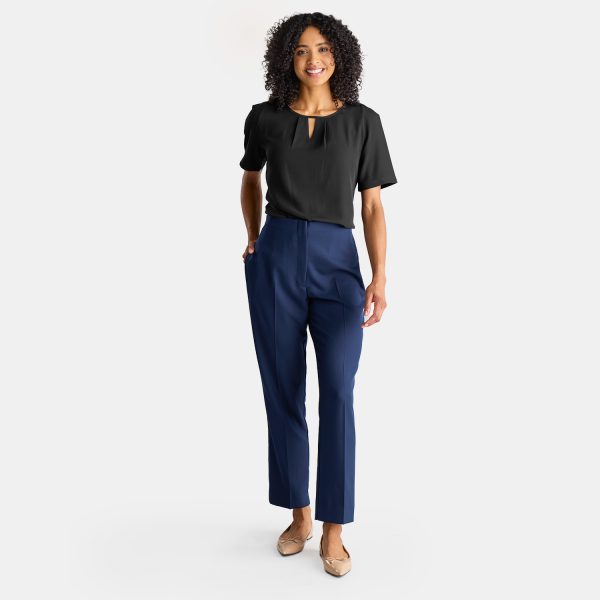 a Woman Wearing a Tucked in Black Work Shirt with High Waisted Navy Straight Leg Pants. the Sale Short Sleeve Top is Work Uniform. the Keyhole Blouse is Comfortable and Stylish, Made by Designs to You.