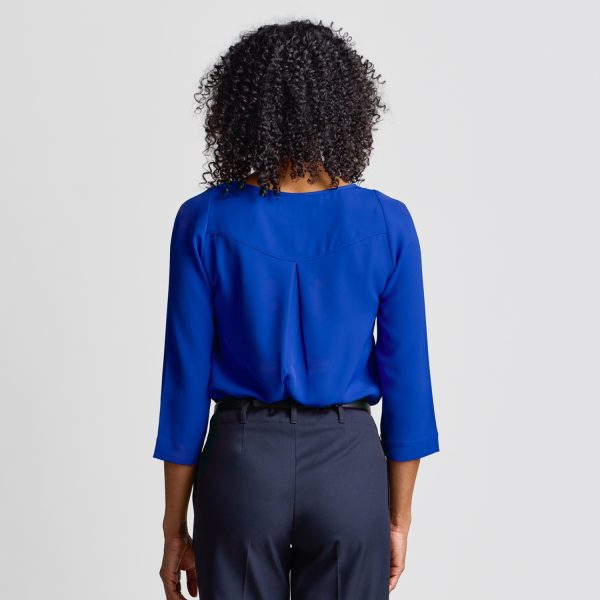 Rear View of a Woman in a Royal Blue Keyhole Blouse with Three-quarter Sleeves, Paired with Dark Trousers.