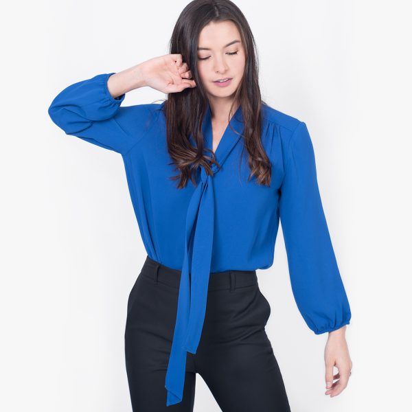 a Woman in a Vibrant Royal Blue Tie-front Blouse, Elegantly Paired with Black Trousers.