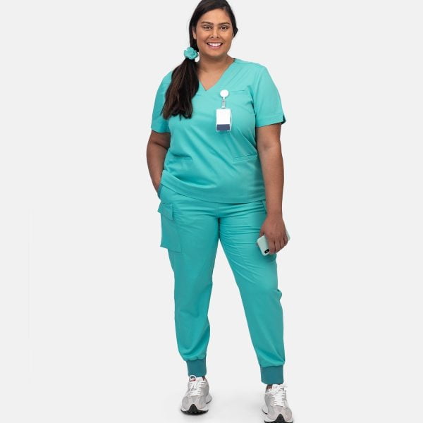 Full Body Image of a Plus Sized Women Wearing Designs to You Coolmint Scrubs, Showcasing Their Stylish Design and Functionality with Two Front Pockets. These Scrubs Are Currently on Final Sale, Offering a Great Opportunity to Grab Them at a Discounted Price.