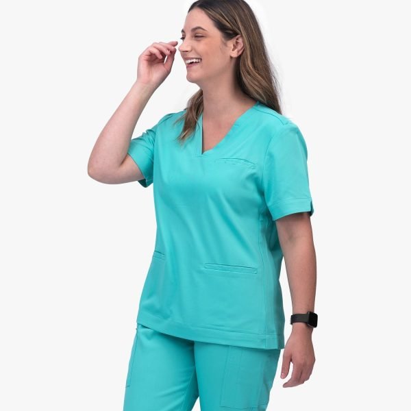 a Women Wearing Designs to You Coolmint Scrubs, Showcasing Their Stylish Design and Functionality with Two Front Pockets. These Scrubs Are Currently on Final Sale, Offering a Great Opportunity to Grab Them at a Discounted Price.