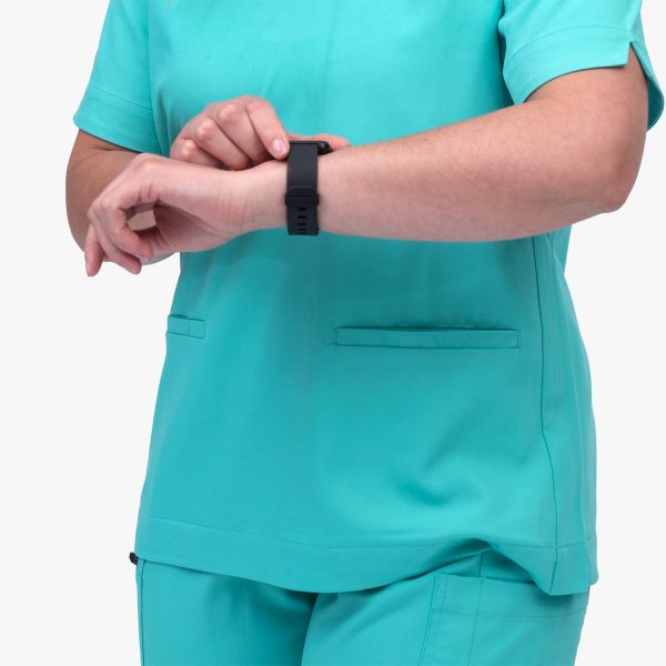 a Close Up of a Women Wearing Designs to You Coolmint Scrubs, Showcasing Their Stylish Design and Functionality with Two Front Pockets. These Scrubs Are Currently on Final Sale, Offering a Great Opportunity to Grab Them at a Discounted Price.