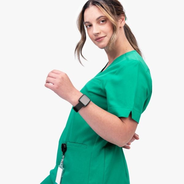 Close Up Image of a Plus Size Women Confidently Wearing the Designs to You Og Green Modern Scrubs Top, Showcasing Its Functional Design with Three Deep Pockets and Four-way Stretch Fabric. the Scrubs Offer Both Style and Comfort, Making Them an Excellent Choice for Healthcare Professionals.