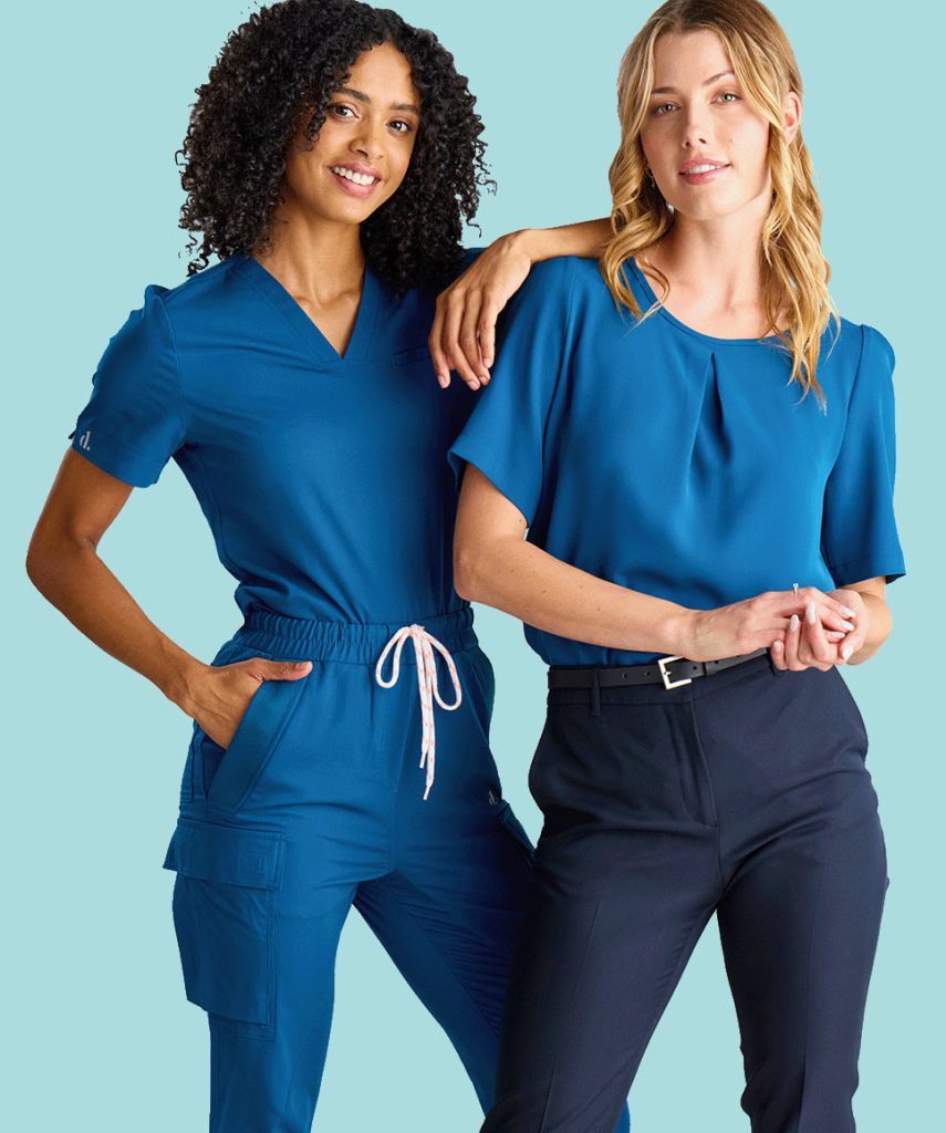 a Photo of Two Smiling Women Wearing Designs to You Healthcare Uniforms.