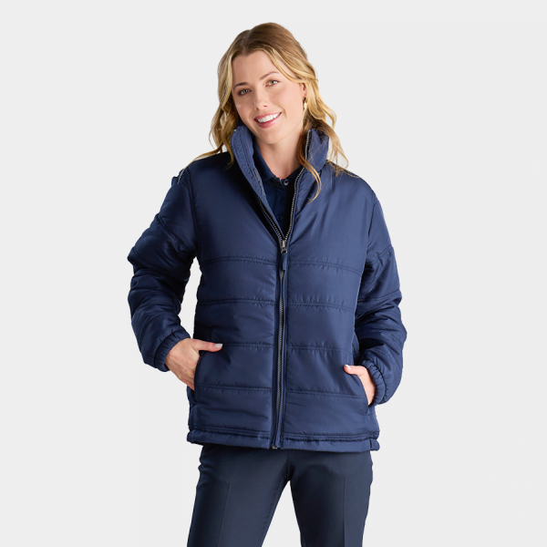 Smiling Woman in a Navy Blue Insulated Puffer Jacket with a High Collar and Zipper Front, Paired with Matching Navy Work Pants, Ideal for a Corporate Outerwear Uniform