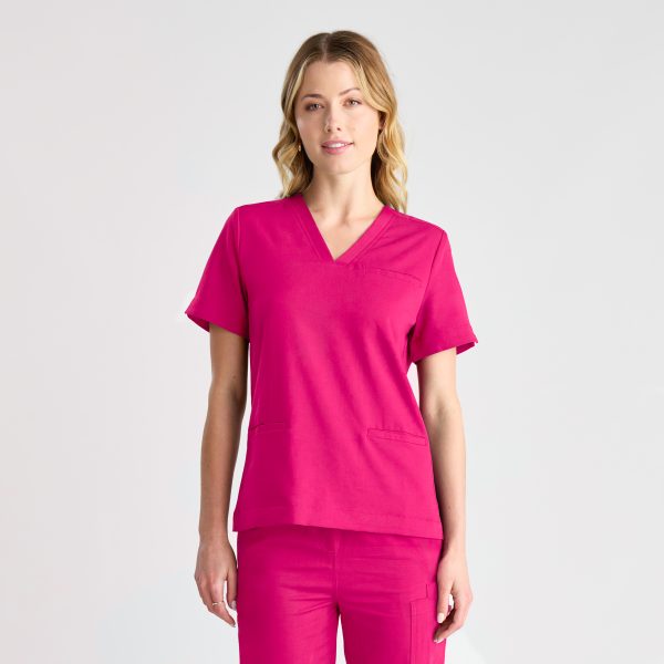 Frontal View of a Woman Dressed in a Fuchsia Pink Women's Modern Scrub Top.