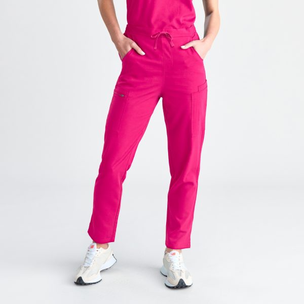 a Woman Poses with Her Hands on Her Hips, Dressed in Fuchsia Pink Women's Modern Scrub Pants with a Drawstring Waist, Demonstrating Both Comfort and Functionality.