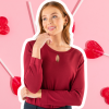 a Young Woman in a Maroon Top with a Keyhole Neckline Detail by Designs to You, Posing Thoughtfully with Her Hand on Her Chin. She is Superimposed on a Pastel Pink Background Adorned with Heart-shaped Lollipops.