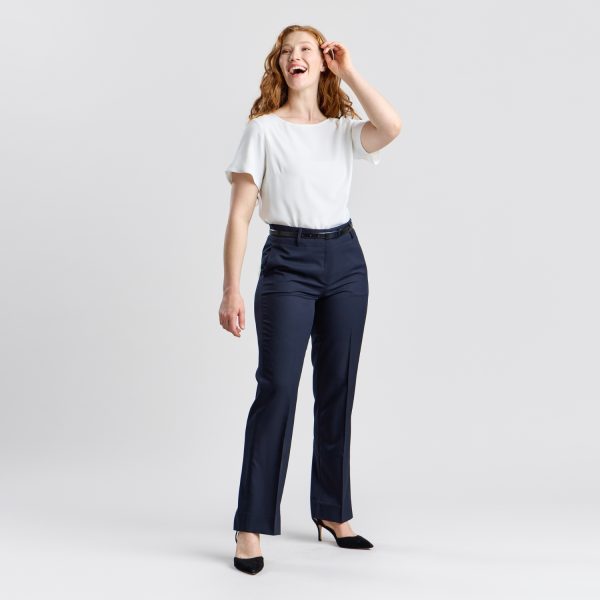 Full-body Shot of a Smiling Woman in Designs to You's Relaxed Leg Pant with Elastic Back in French Navy, Paired with a White Blouse and Black Heels.