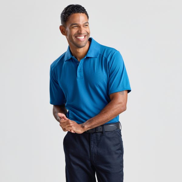 a Man at a 45-degree Angle to the Camera, Smiling in a Men's Eco Bamboo Polo in Aegean Blue, with Hands Gently Clasped.