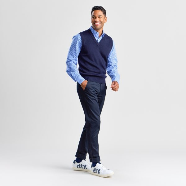 Full-length Image of a Man Walking in a Navy V-neck Pullover Vest and Trousers with White Sneakers, Looking Cheerful.