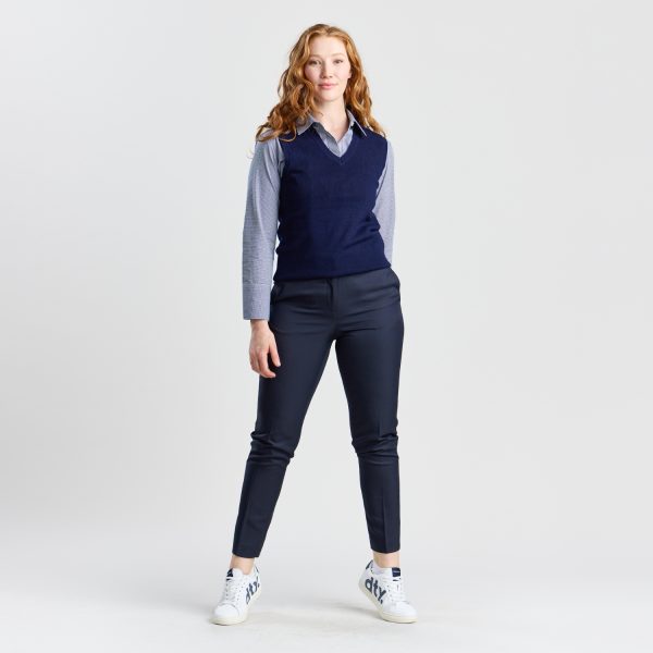 Full-length Image of a Woman in a Navy V-neck Pullover Vest Paired with Navy Trousers and White Sneakers, Standing Relaxed.