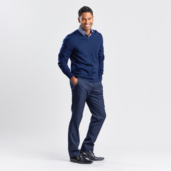 Full-length Image of a Man Standing Confidently in a Navy V-neck Pullover, Navy Trousers, and Black Dress Shoes.