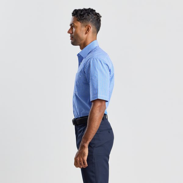 Side View of a Man Wearing a Blue Checkered Short Sleeve Shirt and Navy Trousers.