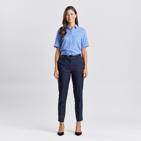 Full Body Shot of a Woman Standing, Dressed in a Blue Checkered Short Sleeve Shirt and Navy Trousers.