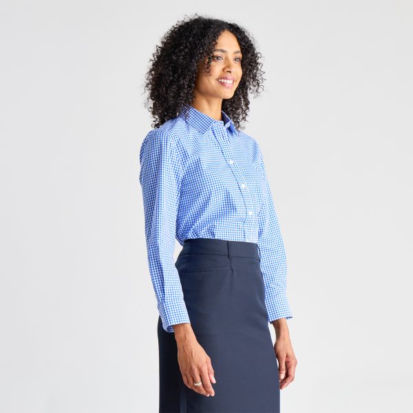 Side View of a Smiling Woman Wearing a Blue Checkered Long Sleeve Shirt Tucked into a Navy Skirt