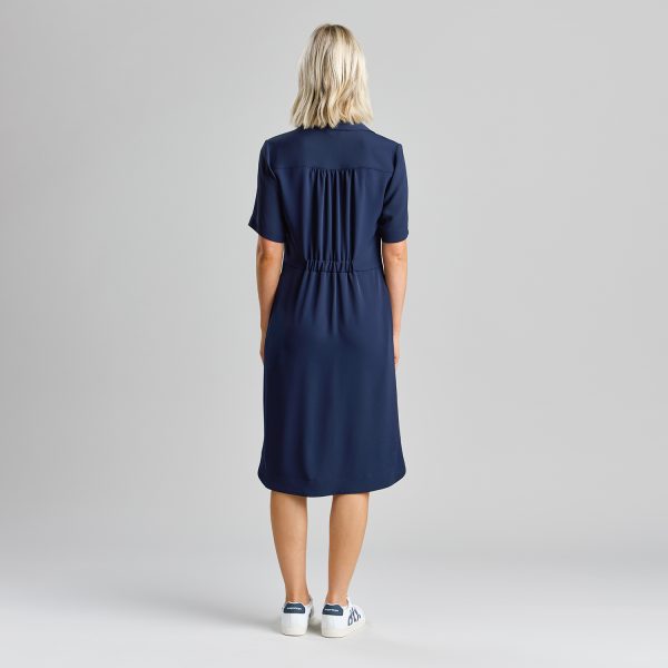 Woman Wearing a Navy Healthcare Shirt Dress, Shown from Behind, with Slight Gathering at the Waist.