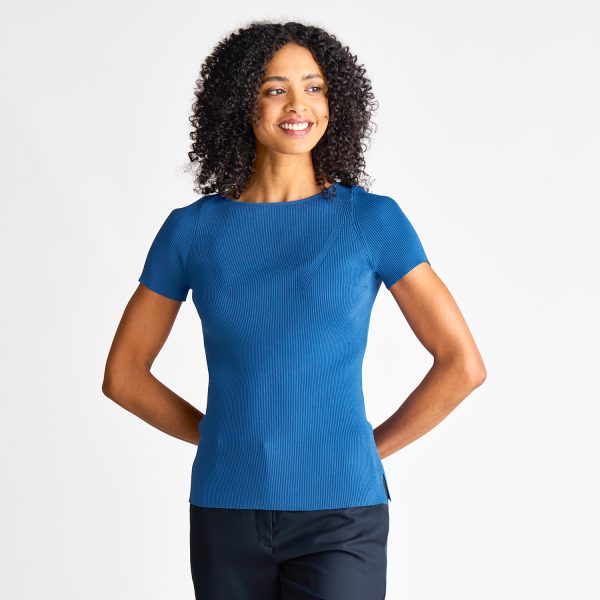 Woman in a Blue Short Sleeve Milano Knit Boat Neck Top, Hands by Her Sides, Paired with Navy Pants.